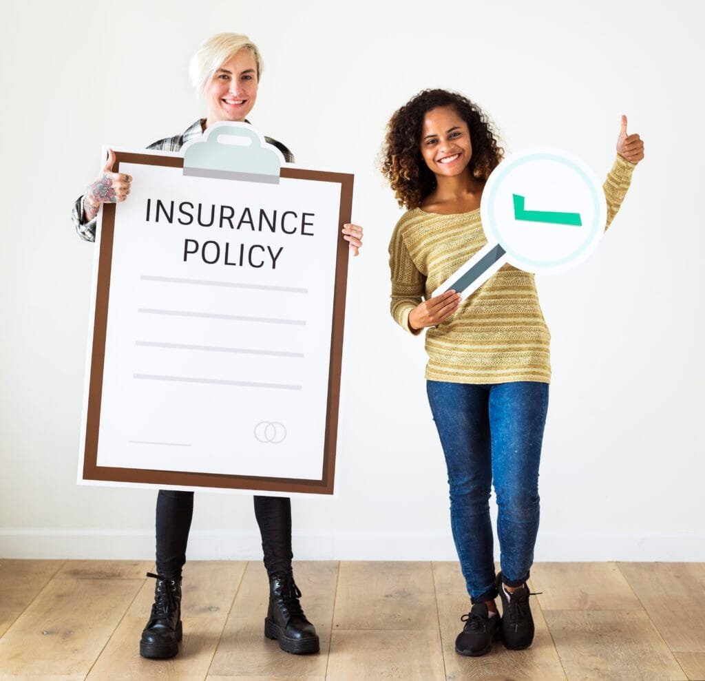 Women holding insurance policy and magnifying glass signs.