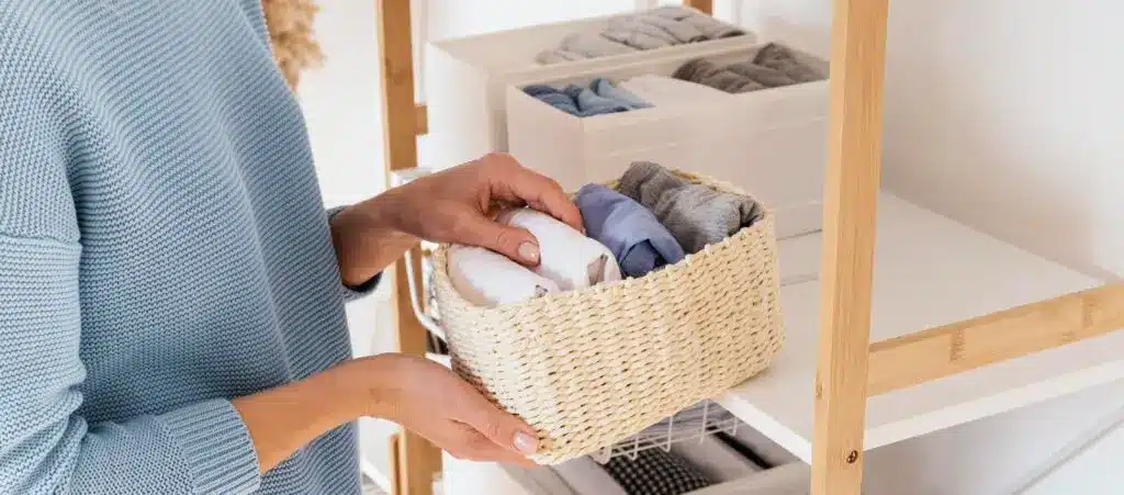 Person organizing clothes in a woven basket